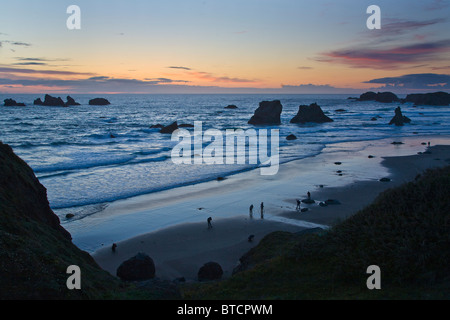 Les photographes qui se profile sur Bandon plage au coucher du soleil avec seastacks sur la côte de l'océan Pacifique de l'Oregon Bandon Banque D'Images