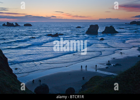 Les photographes qui se profile sur Bandon plage au coucher du soleil avec seastacks sur la côte de l'océan Pacifique de l'Oregon Bandon Banque D'Images