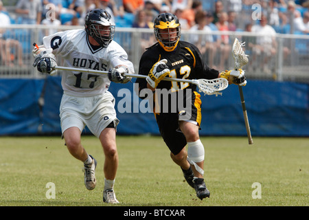 Un joueur Towson University (r) attaques comme un adversaire de l'Université de Georgetown (l) défend au cours d'un jeu de tournoi NCAA lacrosse. Banque D'Images