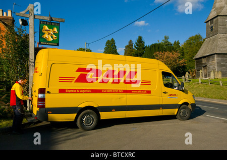 Chauffeur en uniforme l'ouverture de la porte arrière d'un véhicule fourgonnette de livraison DHL Jaune Banque D'Images