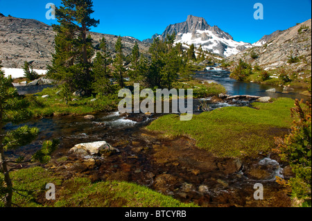 Ruisseau coule à travers pré vert ci-dessous Banner Peak et Thousand Island Lake, la Sierra Nevada, en Californie Banque D'Images