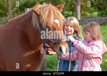 Deux petites filles haltering un poney Banque D'Images