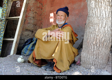 Un homme âgé se reposant dans l'ombre d'un arbre Banque D'Images