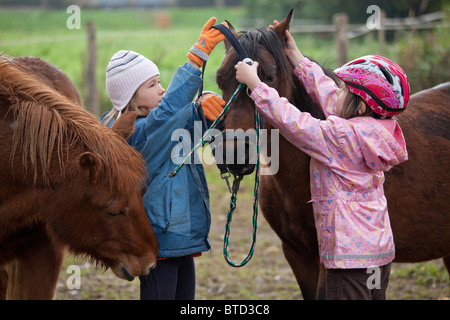 Portrait de deux fillettes haltering un poney Banque D'Images