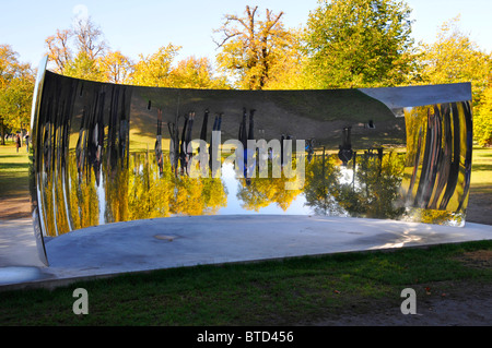 Touristes à Kensington Gardens regardant des images reflétées d'eux-mêmes dans l'un des Anish Kapoor Sky Mirrors C Curve Londres Angleterre Royaume-Uni Banque D'Images