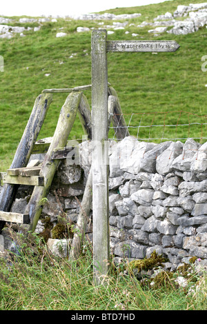 Une échelle en bois et un marqueur de chemin dans le parc national de Yorkshire Dales menant aux puits d'eau près de Malham Village et Cove Banque D'Images