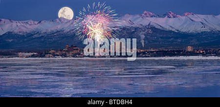 Vue panoramique de lune qui s'élève au-dessus de l'Ancrage skyline et Montagnes Chugach au crépuscule avec Fireworks les frais généraux, l'Alaska, COMPOSITE Banque D'Images