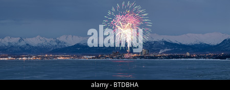 Vue panoramique de lune qui s'élève au-dessus de l'Ancrage skyline et Montagnes Chugach au crépuscule avec Fireworks les frais généraux, l'Alaska, COMPOSITE Banque D'Images