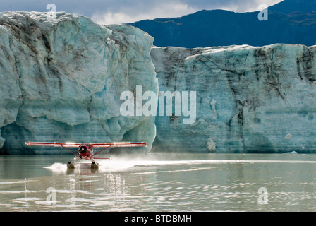 Un de Havilland Beaver décolle du lac de rivage au bord du Triumvirat glacier des montagnes Tordrillo, Alaska Banque D'Images