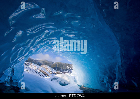 Vue depuis l'intérieur d'une grotte de glace à l'extérieur à la neige paysage, Mendenhall Glacier près de Juneau en Alaska, Winter Banque D'Images