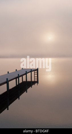 Un brouillard lever du soleil sur un quai dans le lac Basket pendant l'hiver, Bellingham, Washington, USA Banque D'Images