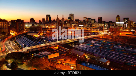 Le lever du soleil sur la ville de Johannesburg avec Nelson Mandela Bridge et les cours de triage de Park Station. Banque D'Images