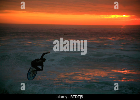 La capture d'un surfeur vague au coucher du soleil Banque D'Images