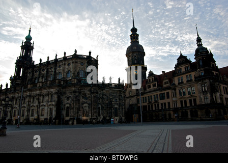 Flèches de cathédrale et le palais royal en silhouette pavée de pierre de l'historique plaza Theaterplatz Dresde Altstadt au lever du soleil Banque D'Images