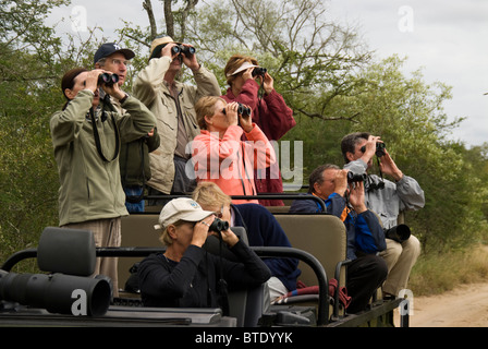 Les touristes en safari véhicule regarde la partie dans les jumelles Banque D'Images