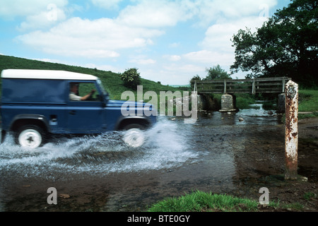 Landrover 90 éclabousse à travers la rivière ford à Bradbourne, Peak District National Park. ROYAUME-UNI Banque D'Images