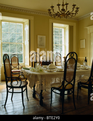 Chaises en bois cintré antique au set de table pour le déjeuner avec un chiffon blanc en dentelle en salle à manger avec parquet au sol Banque D'Images