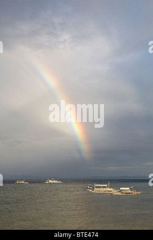 Un arc-en-ciel du matin s'allume l'eau juste à côté de l'Île Cabilao, Bohol, Philippines, l'océan Pacifique. Banque D'Images