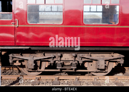 Un ancien wagon de chemin de fer à Sheringham, Norfolk. Gros plan sur les roues et les suspensions à ressorts à lames. Banque D'Images