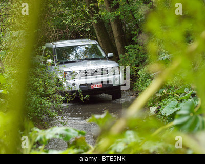 Land Rover Discovery 4 argent de la conduite dans un ruisseau au domaine d'Arthey en Belgique Banque D'Images