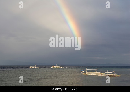 Un arc-en-ciel du matin s'allume les eaux entourant l'Île Cabilao, Bohol, Philippines, l'océan Pacifique. Banque D'Images