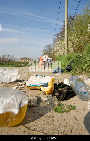 Corbeille sur le chemin de terre, Volontaires dans le nettoyage de l'arrière-plan Banque D'Images