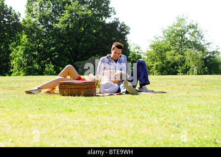 Couple enjoying picnic in park Banque D'Images