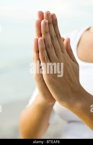 La femme les mains jointes en position de prière Banque D'Images