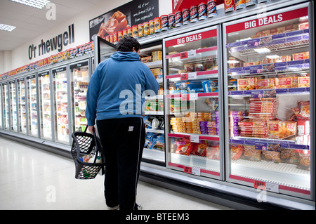 Un homme à la recherche d'un article dans la section d'aliments surgelés de Supermarché Coop, UK Banque D'Images