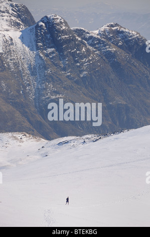 Walker en hiver entre les montagnes dans le Lake District. Langdale Pikes dans l'arrière-plan Banque D'Images