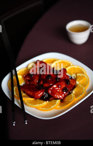 Haricots noirs les tranches d'orange poulet asiatique chinois baguettes délicieux sauce savoureuse Banque D'Images