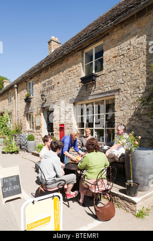 Pause café en plein air à l'extérieur de l'ancien bureau de poste dans le village de Cotswold Guiting Power, Gloucestershire UK Banque D'Images