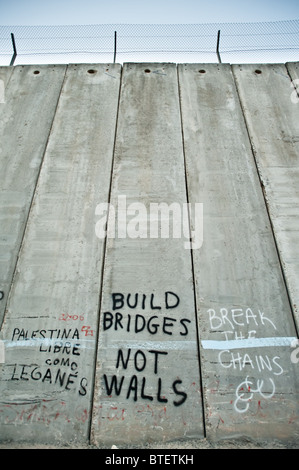 Un graffiti sur le mur de séparation israélien dit, ' construire des ponts, pas des murs," et "briser les chaînes". Banque D'Images