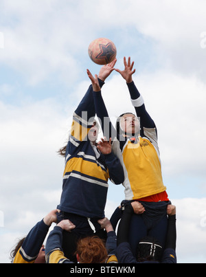 Un joueur de l'Université George Washington (l) et de l'Académie Navale opposant (r) pour atteindre la balle lors d'un match de rugby féminin. Banque D'Images