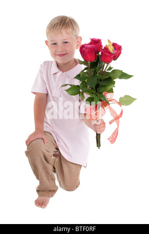 Smiling boy présentant un bouquet de roses rouges Banque D'Images