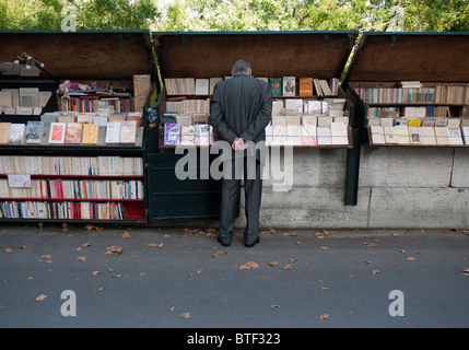 L'homme parcourt en cale livre sur la chaussée à côté de la Seine, dans le centre de Paris France Banque D'Images