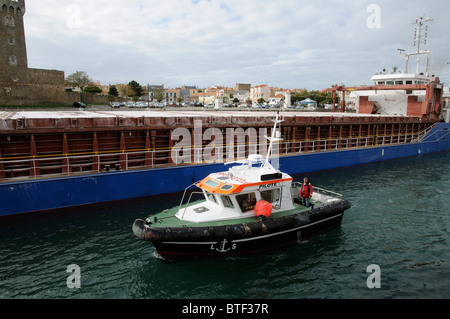 Bateau pilote escortant le Amurdiep de manœuvres de navire à cargaison sèche dans le canal au départ des Sables d''Olonne France Banque D'Images