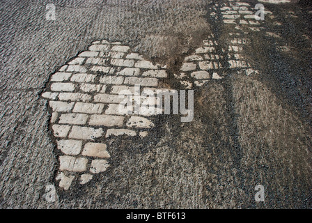 La fondation en pierre apparente sous route macadam effilochés resurfaçage attend Banque D'Images