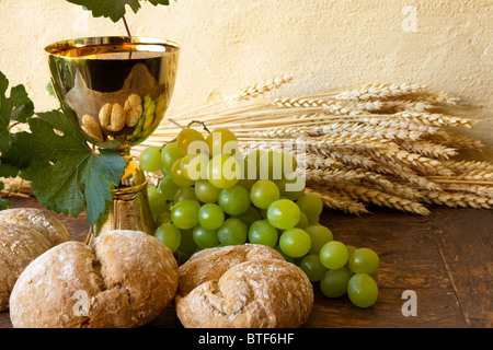 Les raisins et du pain consacré à côté d'un calice doré avec du vin Banque D'Images