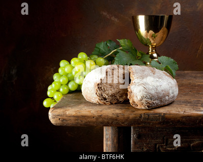 La sainte communion image montrant un calice doré avec des raisins et du pain Banque D'Images