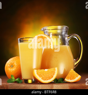 Still Life : oranges, verre de jus et jus de plein pot sur une table en bois. Banque D'Images