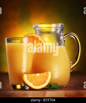 Still Life : oranges, verre de jus et jus de plein pot sur une table en bois. Banque D'Images