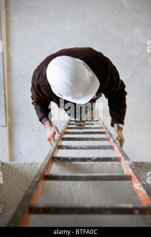 Construction Worker climbing ladder Banque D'Images