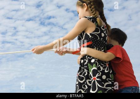 Siblings playing Tug-of-war ensemble Banque D'Images
