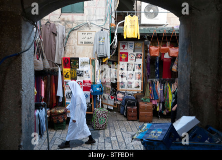 Femme palestinienne voilée marcher dans la vieille ville avec des t-shirts imprimés sur l'écran. Jérusalem Banque D'Images