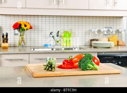 Cuisine intérieur moderne avec des légumes frais sur le comptoir en pierre naturelle Banque D'Images
