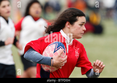 Une université américaine dvd porte la balle contre l'Université du Maryland au cours d'un match de rugby féminin. Banque D'Images