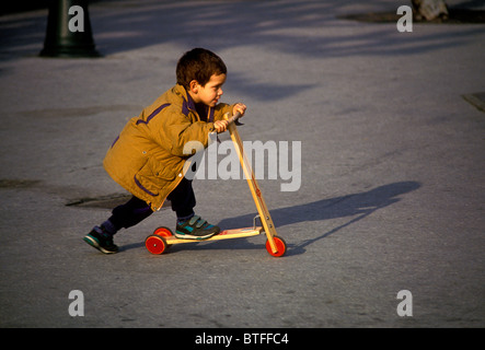 Garçon français, jeune garçon, homme enfant équitation trotinette, Place Louis XIV, Pays Basque, ville de Saint Jean de Luz, Saint Jean de Luz, France Banque D'Images