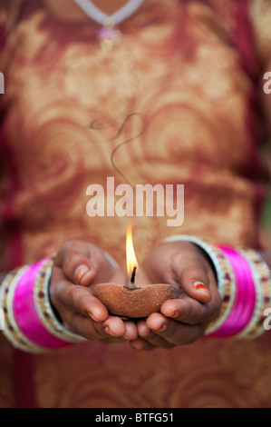 Jeune indienne tenant une lampe à huile allumée. L'Inde Banque D'Images