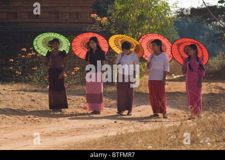 Groupe de cinq jeunes femmes birmanes marcher avec un parasol de couleur, Bagan (Pagan), le Myanmar (Birmanie) Banque D'Images